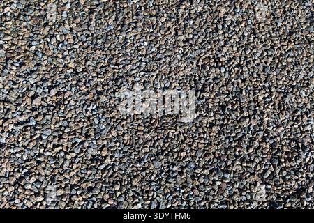 Gray Gravel Texture Background From Above. Top view of small gray gravel stones covering the ground, showing rough natural texture, construction Stock Photo