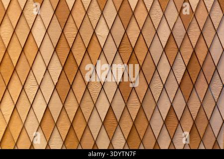 A sophisticated wall surface featuring a repeating diamond geometric pattern with rich earthy tones and textures. Stock Photo