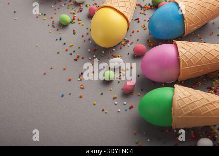 Colorful easter eggs in waffle cones on gray background Stock Photo