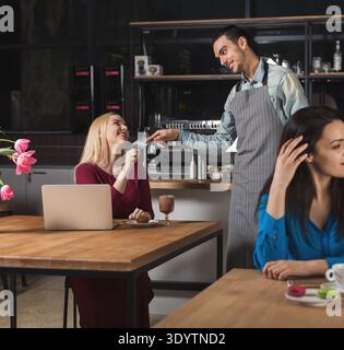 Smiling waiter taking payment from client Stock Photo