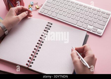 Woman's hands holding pen and spiral notepad Stock Photo