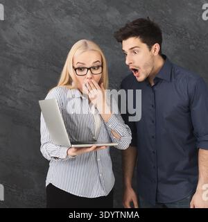 Shocked couple using laptop at studio Stock Photo