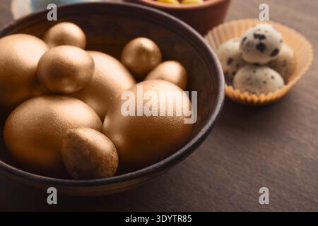 Easter eggs painted in gold color in wooden bowl Stock Photo