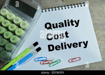Concept of quality cost delivery write on book isolated on Wooden Table. For professional business leadership and operations Stock Photo