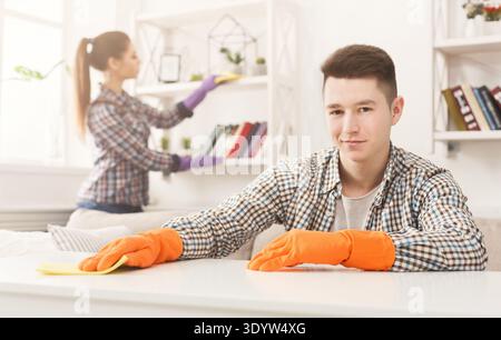 Young couple wiping dust together Stock Photo