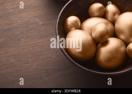 Golden easter eggs in wooden bowl Stock Photo