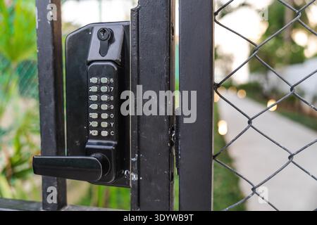 Electronic keypad door lock on metal gate for secure access control to private property Stock Photo