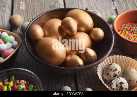 Easter eggs painted in gold color in wooden bowl Stock Photo