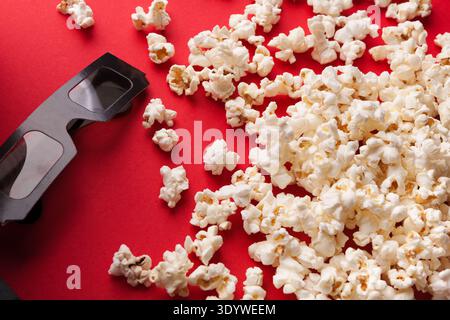 3D glasses and popcorn on red background Stock Photo