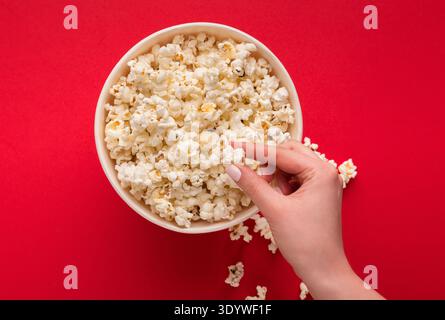 Bucket of popcorn on red background, top view Stock Photo