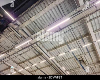 Explore the sleek design of a modern industrial ceiling featuring bright LED lights and metal beams Stock Photo