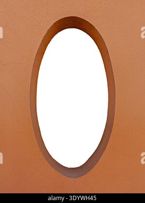 Architectural structure of oval window on terracotta-colored plastered wall. Solid frame with white interior cut out, with clipping path included Stock Photo