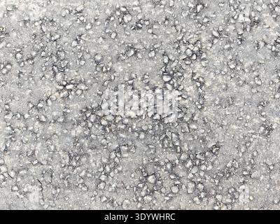 Surface features a textured grey background with small, scattered pebbles. This design can be used for creative projects that require space for text. Stock Photo