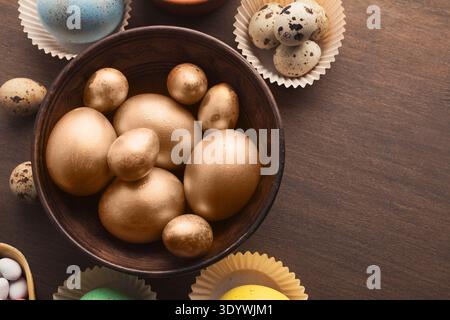 Golden easter eggs in wooden bowl Stock Photo