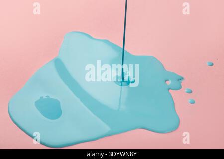 Blue paint flowing on pink background Stock Photo