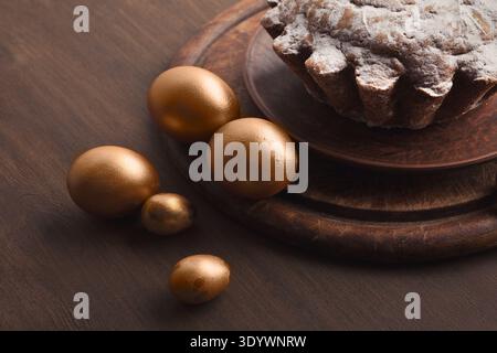 Golden eggs and easter cake on table Stock Photo