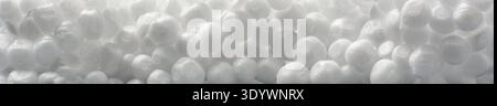 white styrofoam piece full frame texture in macro close-up, compressed spherical polystyrene beads with textured finish, industrial packaging Stock Photo