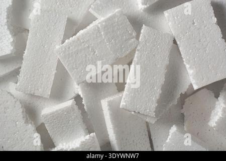 pile of discarded broken white styrofoam pieces in full frame texture, flat expanded polystyrene foam boards in top view, packaging waste Stock Photo
