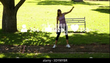 Stretching woman in purple tank, leggings on park path with white bench, earbuds, social icons Stock Photo