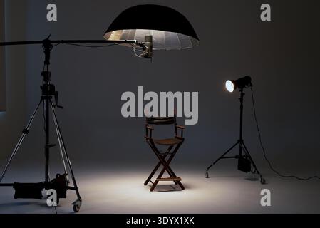 Professional photo studio setup with a director's chair, studio lights, softbox, flash on a boom Stock Photo