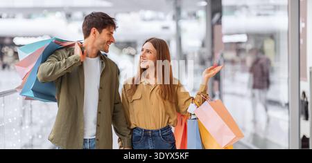 Couple Enjoys Shopping Together in a Busy Mall on a Sunny Day Stock Photo