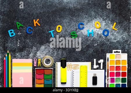 Back to School Creative Flat Lay with Colorful Letters, Stationery, Notebooks, Paints and Office Supplies on Dark Chalkboard Background, Bright Educat Stock Photo