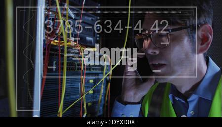 Inspecting Korean tech wearing hi-vis vest checking server rack in server room, HUD, copy space Stock Photo