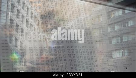 Displaying translucent display showing hexadecimal dump in office atrium with reflected facade Stock Photo