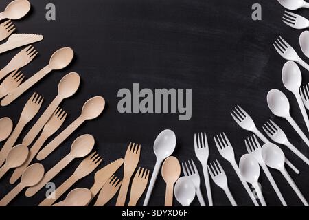 Environmentally friendly wooden cutlery vs plastic soons and forks Stock Photo