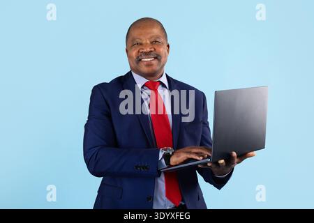 Mature african american businessman using laptop on studio background Stock Photo