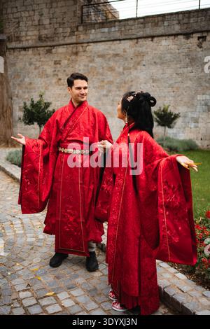 Multicultural couple celebrating marriage in traditional Chinese attire Stock Photo