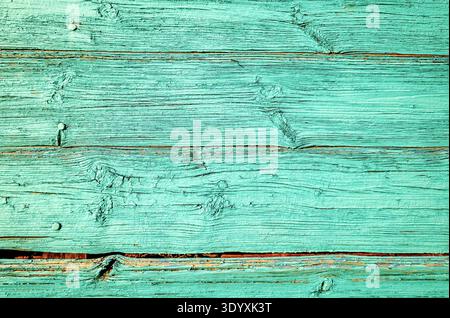 Old rough wooden boards with cracks as creative background in green color. Wooden planks texture with the shabby paint Stock Photo