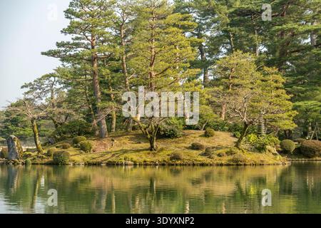 Pine-covered island reflected in a calm pond at Kenrokuen Garden, Kanazawa, Japan. Stock Photo