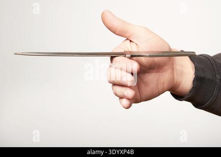 Finding of balance point of throwing knife on fingers Stock Photo
