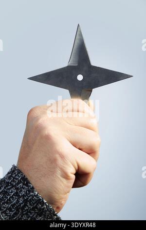 Throwing shuriken weapon for training of fight and sport throwing in hand Stock Photo