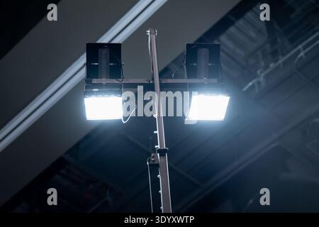 Bright twin panel lights mounted on a stand in an indoor venue hall, ideal for exhibition setup, rental equipment, and temporary site lighting use Stock Photo