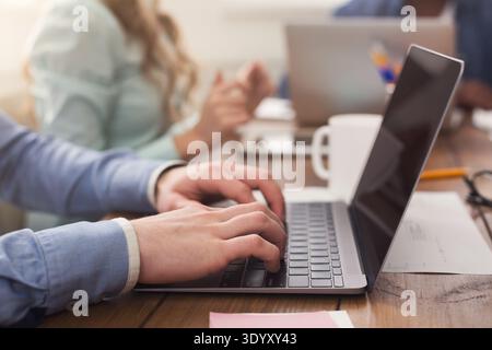 Businesspeople working on laptop in office Stock Photo