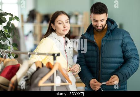 Couple trying on jackets in a clothing store Stock Photo