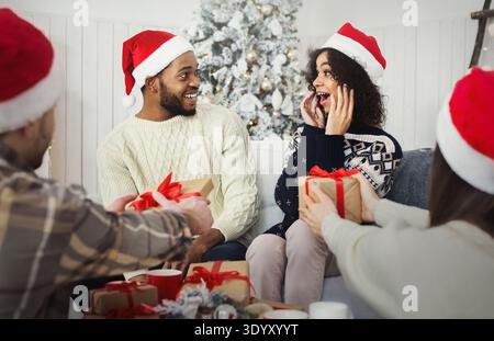 Surprised african-american couple getting Christmas presents Stock Photo