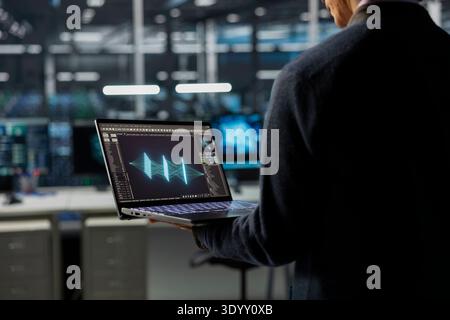 Data center technician monitoring AI systems, adjusting deep learning parameters. Server room admin in office enhancing artificial intelligence neural networks performance Stock Photo