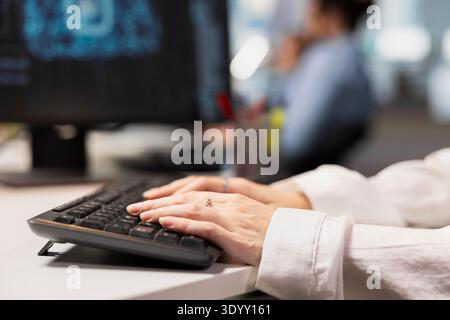 Close up of engineer writing code snippets in modern workplace, adjusting configurations. IT professional typing on PC keyboard, running diagnostic tools, monitoring API cloud services Stock Photo
