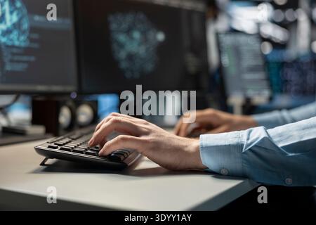 Close up of data center technician coding on PC to update server tech, configuring equipment using software tools. Server room employee types on computer keyboard, ensuring reliable network operations Stock Photo