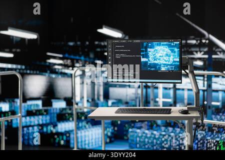 Industrial platform with high desk in automated data center shows machine learning code on screen. Server farm systems running AI models monitoring operational stability and algorithm efficiency. Stock Photo