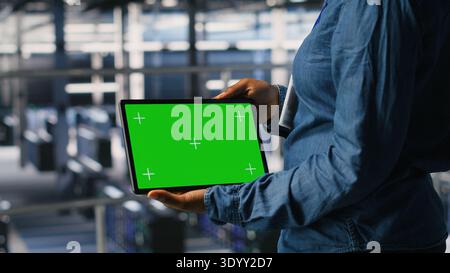 Server hub engineers finetuning configurations using chroma key device. Close up of technicians on data center industrial platform analyzing performance outputs on isolated screen tablet Stock Photo
