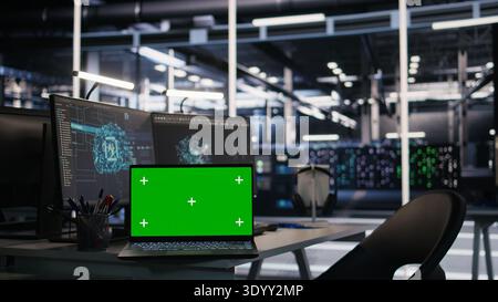 Chroma key notebook and PCs in high tech data center workspace used for AI system monitoring and performance tracking. Mockup notebook overseeing server racks involved in computing operations Stock Photo