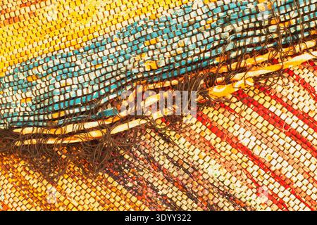 Macro photograph of colourful hand-woven textile with frayed edge Stock Photo