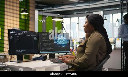 Female technician writing code on PC, developing neural networks APIs. System administrator using computer to troubleshoot software errors with artificial intelligence technology, camera A Stock Photo