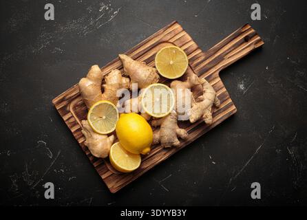 Ginger root with lemon on a wooden board Stock Photo