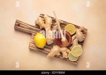 Ginger root, lemon and honey on a wooden board Stock Photo