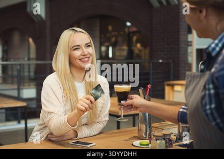 Barista taking payment from client Stock Photo